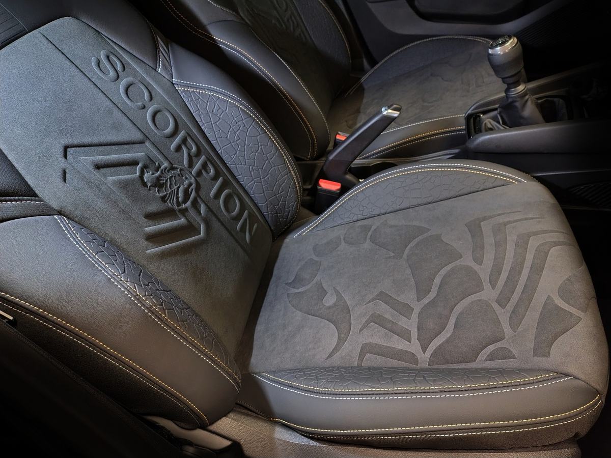 Scorpion-Sitz im Auto: dunkelgrauer Velours und Leder, Scorpion-Schriftzug und Skorpion im Relief auf der Rückenlehne