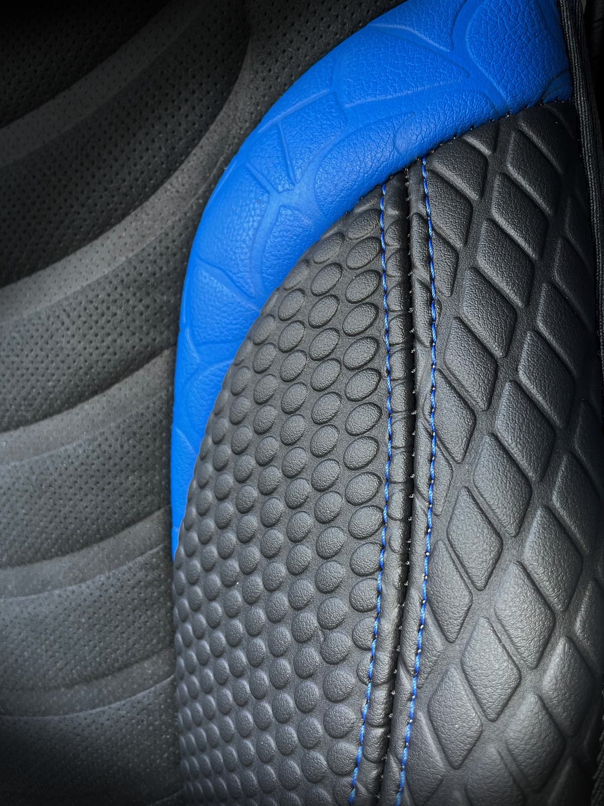 MAN Cobra — Ein MAN-Fahrerhaus in dunkelgrauem Leder mit leuchtend blauen Details. Ein Schlangenhautmuster zieht sich über Sitze, Lenkrad und Türverkleidungen, das Blau verbindet das ganze Interieur zu einer Einheit.