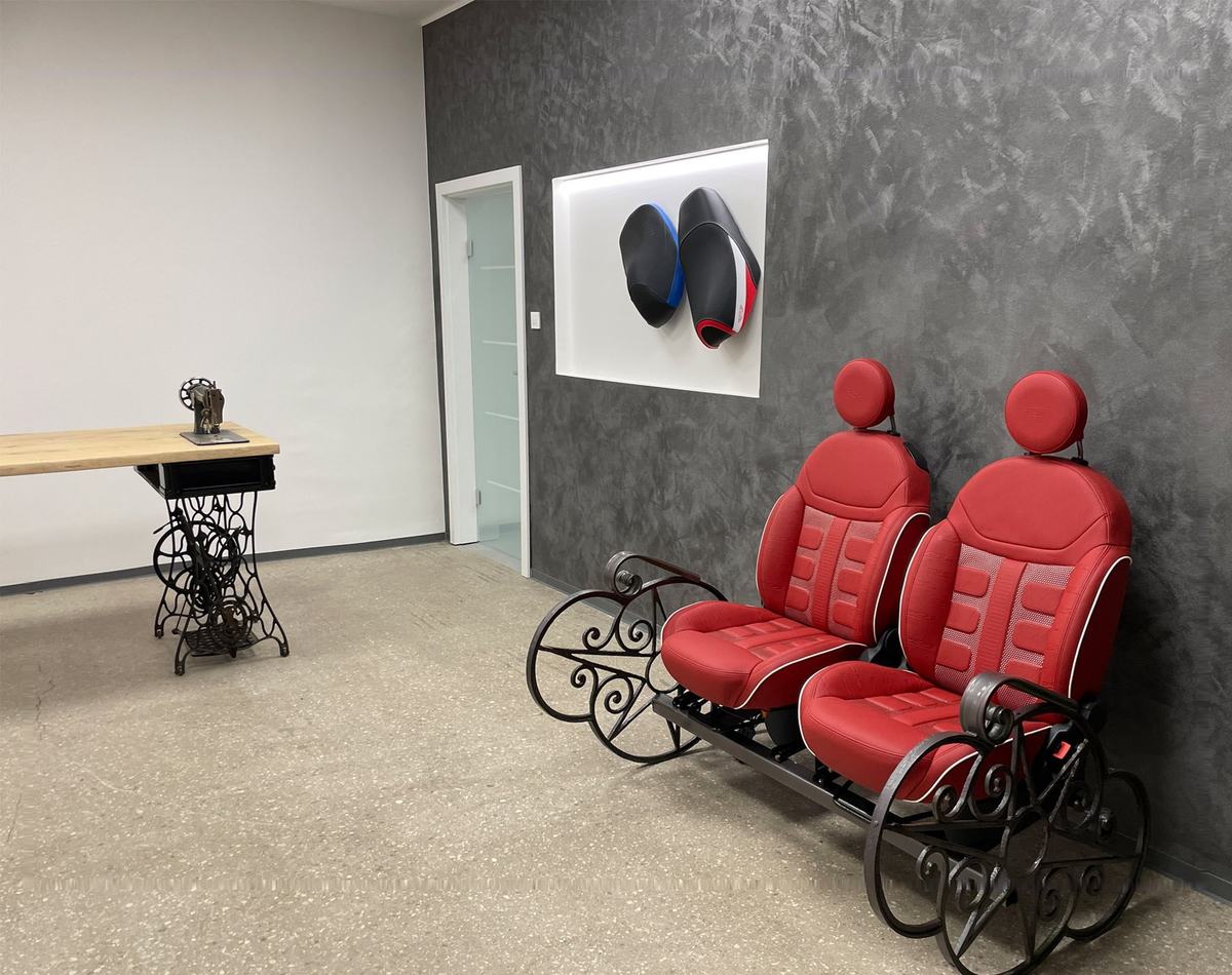 The POL showroom: red seats on a wrought-iron stand and motorcycle seats on the wall